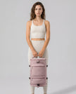 Model carrying ShiftForm Carry Pack in dusty pink styled for gym and everyday movements