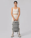 Model carrying ShiftForm Carry Pack in gray styled for gym and everyday movements