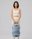 Model carrying ShiftForm Carry Pack in light blue styled for gym and everyday movements