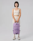 Model carrying ShiftForm Carry Pack in lilac styled for gym and everyday movements