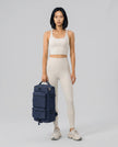 Model carrying ShiftForm Carry Pack in navy styled for gym and everyday movements