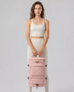 Model carrying ShiftForm Carry Pack in watermelon pink styled for gym and everyday movements