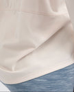Close-up of Athlesi SoftFlow soft stretch fabric hem & stitching in cream