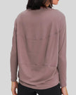 Back view of Athlesi SoftFlow relaxed long sleeve top in dusty pink