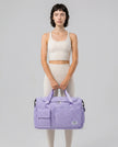Model holding SoftForm Carry Bag in lavender styled for everyday and gym movement