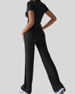 Back view of model wearing black Athlesi SoftForm short sleeve top and pant set