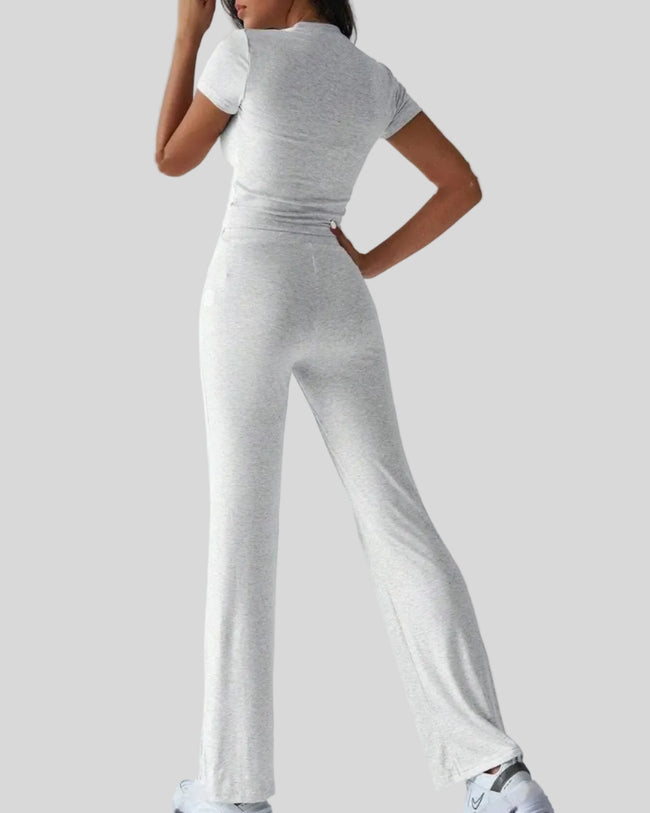 Back view of model wearing light gray Athlesi SoftForm short sleeve top and pant set