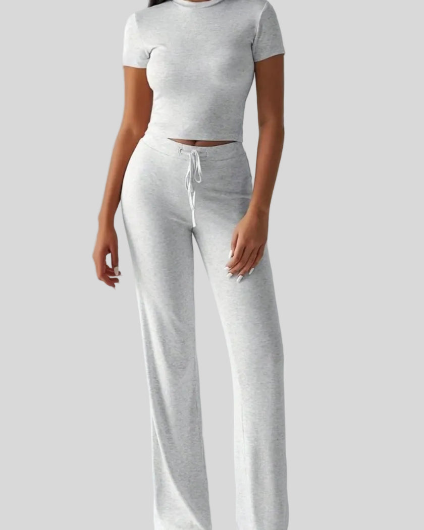 Model wearing light gray Athlesi SoftForm short sleeve top and pant set front view