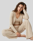 Woman sitting while wearing the SoftNest Lounge Set in beige with relaxed cardigan and lounge pants