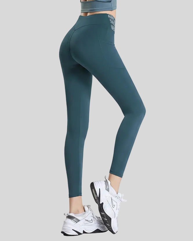 Back angle view of deep teal Statement Angel Legging with cropped sporty fit