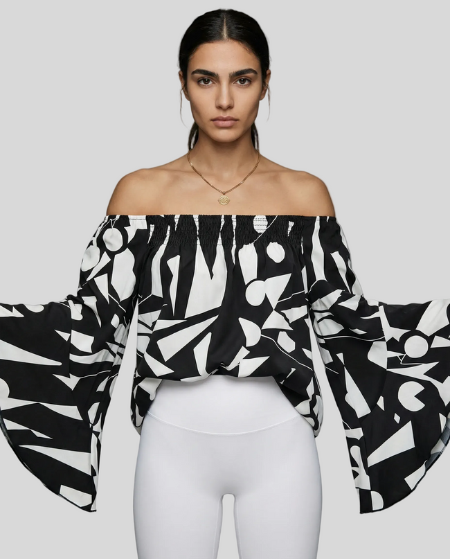 StreetBloom off-shoulder blouse in black styled with white Athlesi leggings front angle view