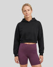 Upper body front view of woman wearing StudioEase Cropped Hoodie in Black
