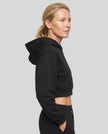 Side view of woman wearing StudioEase Cropped Hoodie showing cropped silhouette and sleeve shape