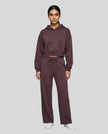 Full body front view of woman wearing Dark Reddish Purple StudioEase Cropped Hoodie with matching sweatpants.