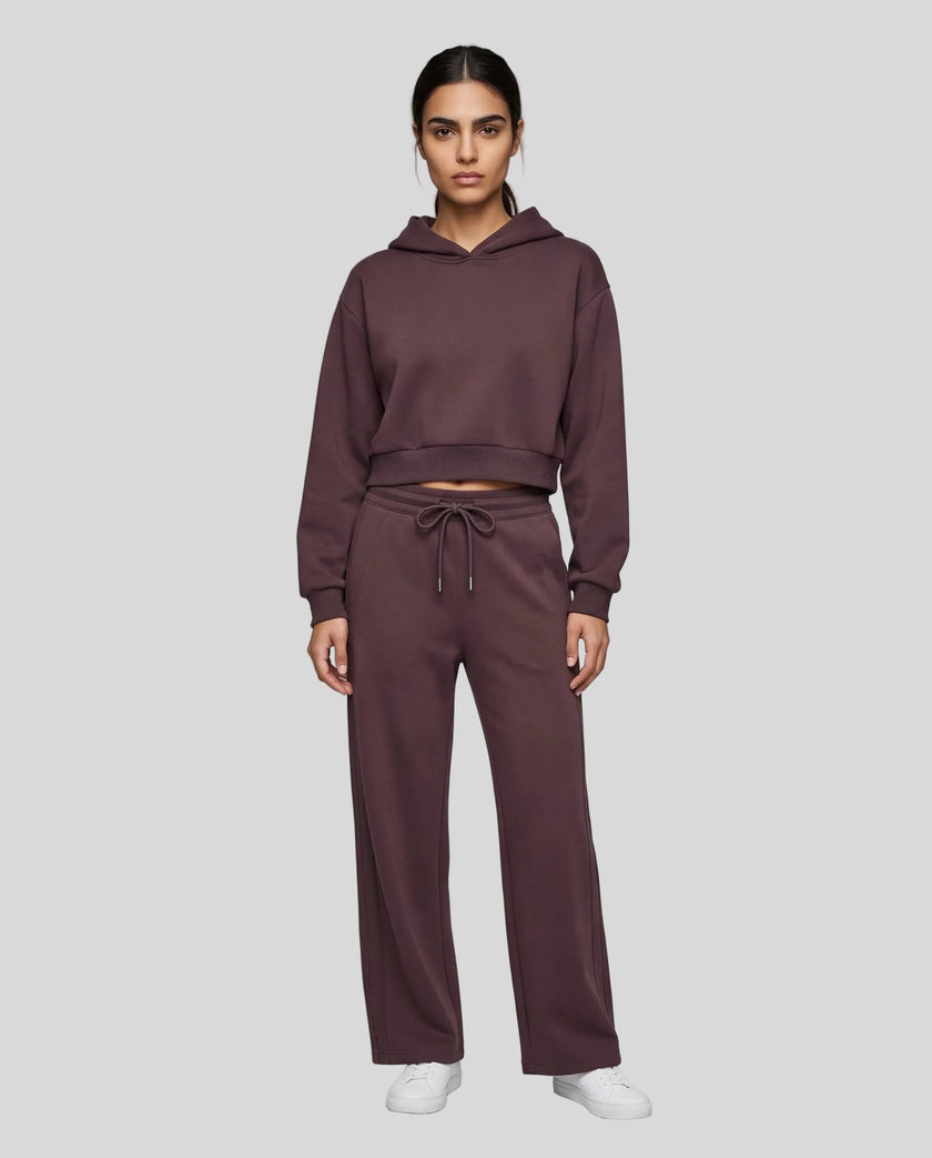 Full body front view of woman wearing Dark Reddish Purple StudioEase Cropped Hoodie with matching sweatpants.