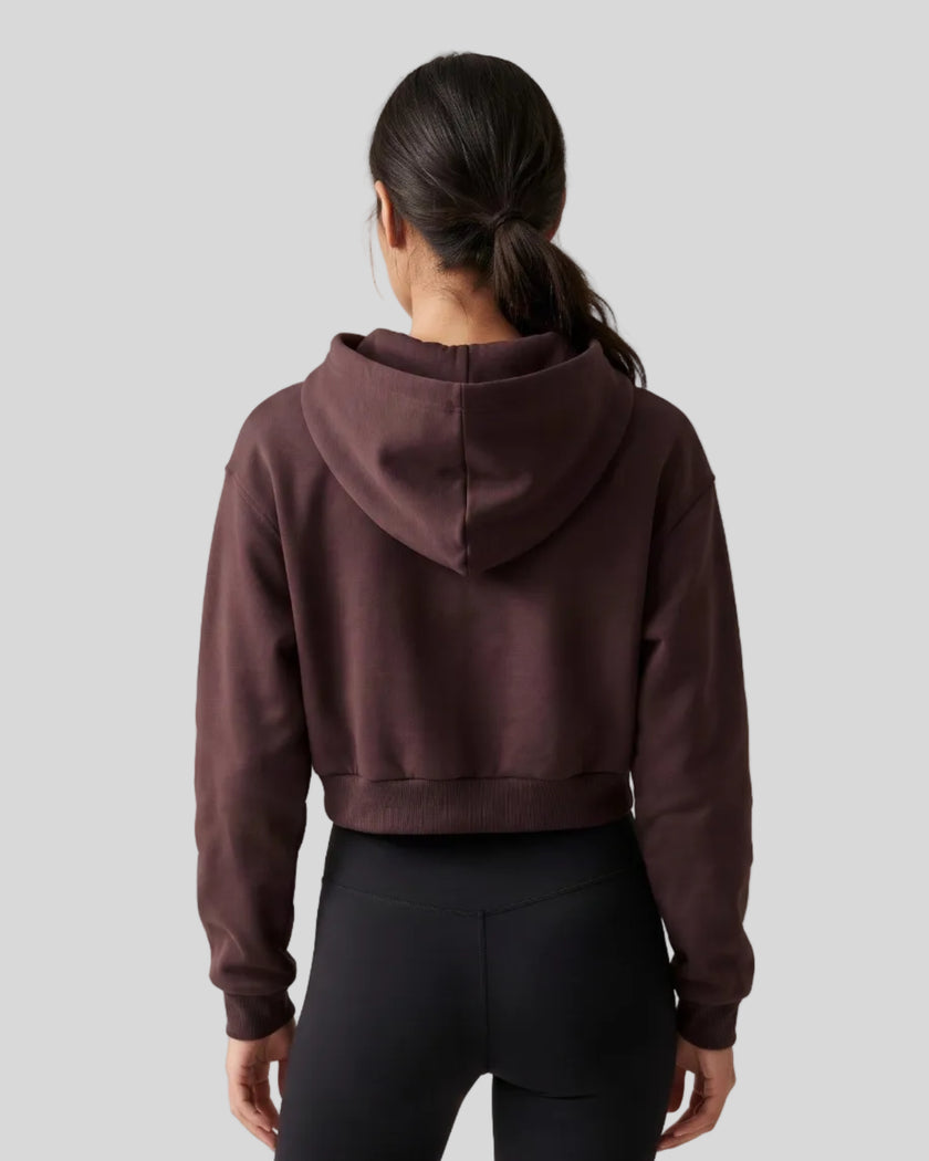 Upper body back view of woman wearing StudioEase Cropped Hoodie showing hood and ribbed hem