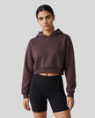 Upper body front view of woman wearing StudioEase Cropped Hoodie in Dark Reddish Purple