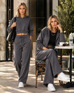 A woman wearing two versions of Athlesi StudioEase Matching Pieces in Charcoal Gray