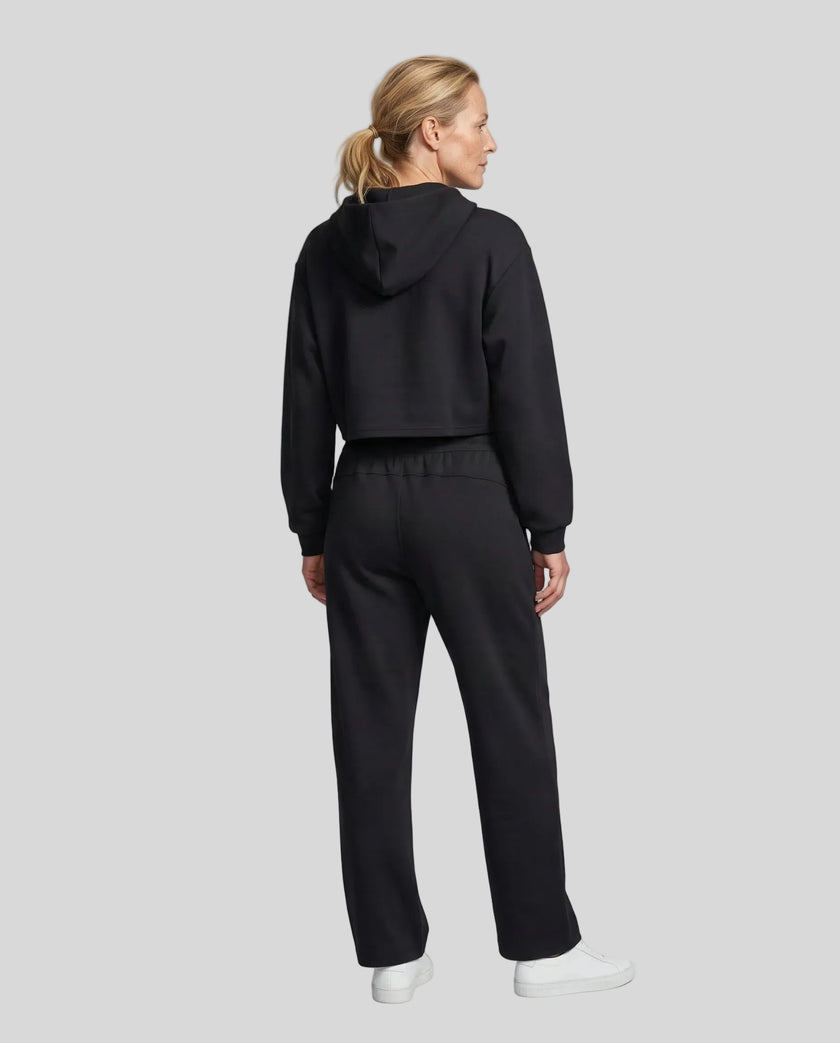 Full body back view of woman wearing black StudioEase Cropped Zip Hoodie in a coordinated casual outfit