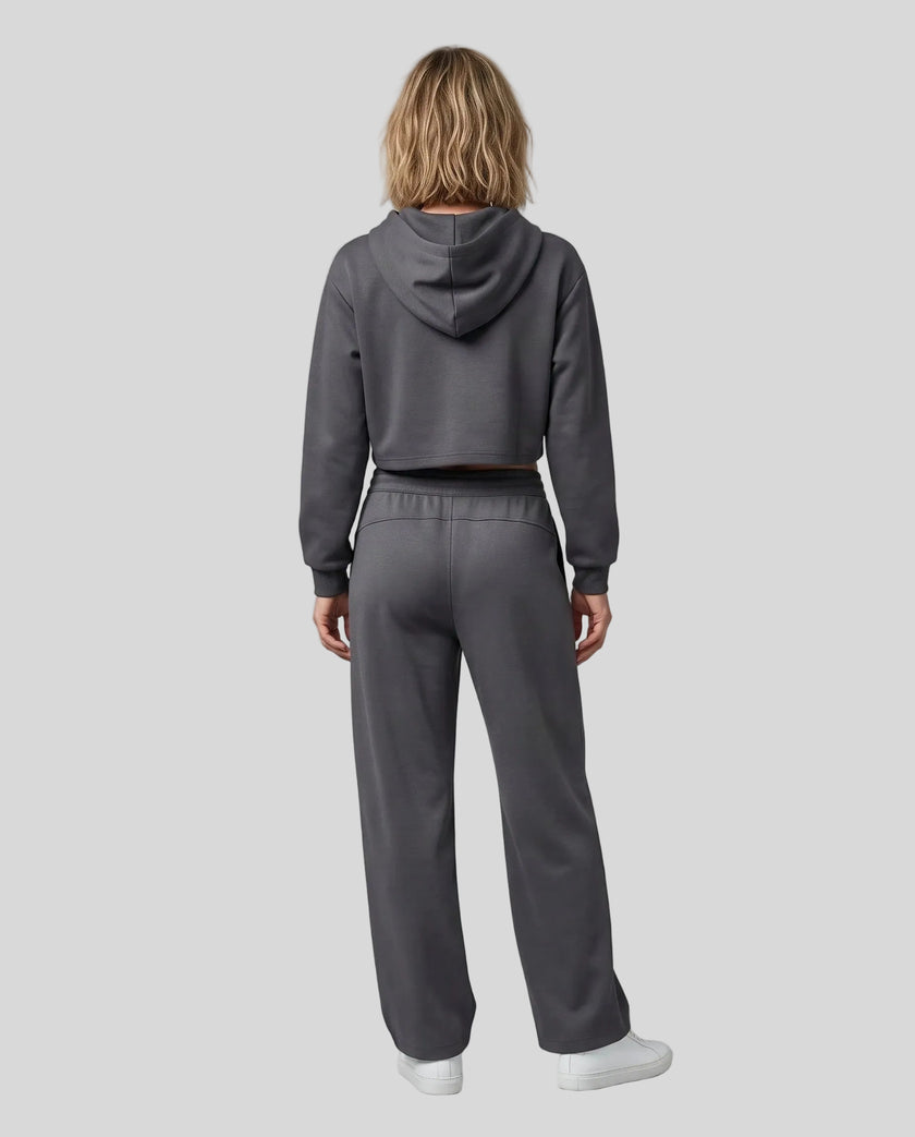 Full body back view of woman wearing charcoal gray StudioEase Cropped Zip Hoodie in a coordinated casual outfit