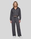 Full body front view of woman styling StudioEase Cropped Zip Hoodie with matching high-waisted sweatpants in Charcoal Gray