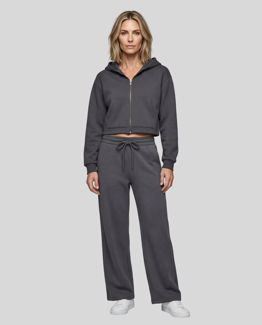Full body front view of woman styling StudioEase Cropped Zip Hoodie with matching high-waisted sweatpants in Charcoal Gray