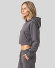 Side view of woman wearing StudioEase Cropped Zip Hoodie showing its relaxed cropped silhouette
