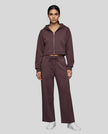 Full body front view of woman styling StudioEase Cropped Zip Hoodie with matching high-waisted sweatpants in Dark Reddish Purple