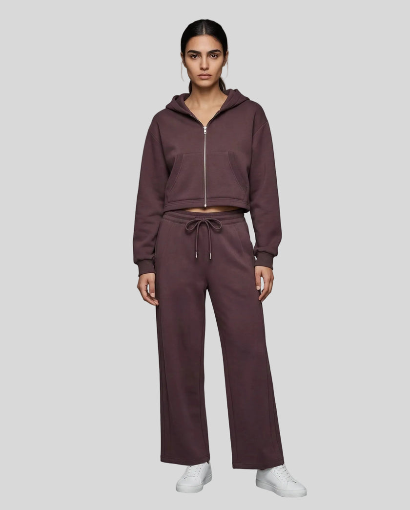 Full body front view of woman styling StudioEase Cropped Zip Hoodie with matching high-waisted sweatpants in Dark Reddish Purple