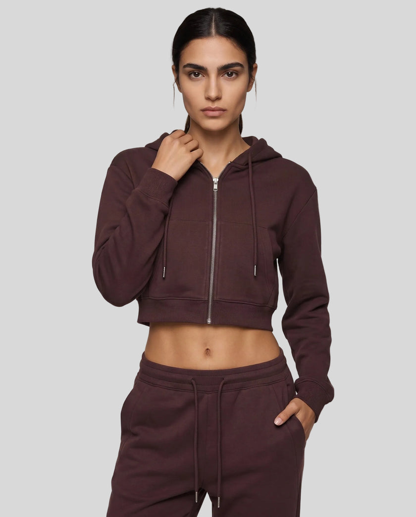 Upper body front view of woman wearing Dark Reddish Purple StudioEase Cropped Zip Hoodie zipped closed with matching sweatpants