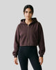 Upper body front view of woman wearing StudioEase Cropped Zip Hoodie zipped closed in Dark Reddish Purple