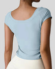 Back view of StudioFlow Short Sleeve Active Top in light blue with smooth finish