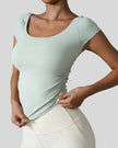 StudioFlow Short Sleeve Active Top in light green, front view with fitted silhouette