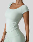 Side view of StudioFlow Short Sleeve Active Top in light green showing rouching detail