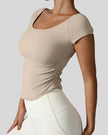 Side view of StudioFlow Short Sleeve Active Top in tan showing rouching detail