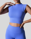 Woman wearing a blue activewear outfit on a gray background