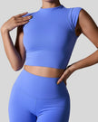 StudioLine High-Neck Tank in blue, front view showing cropped fit and high neckline