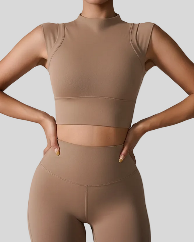 Woman wearing a camel activewear outfit on a gray background