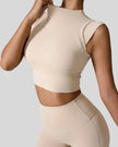 StudioLine High-Neck Tank tan, angled view highlighting clean arm openings and smooth fabric