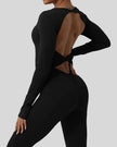 Close-up of twisted open-back detail on StudioTwist jumpsuit in black