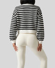 Back view of black striped cardigan featuring soft textured knit and relaxed silhouette
