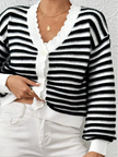 Closeup of black striped knit texture and balloon sleeve detail on cropped cardigan