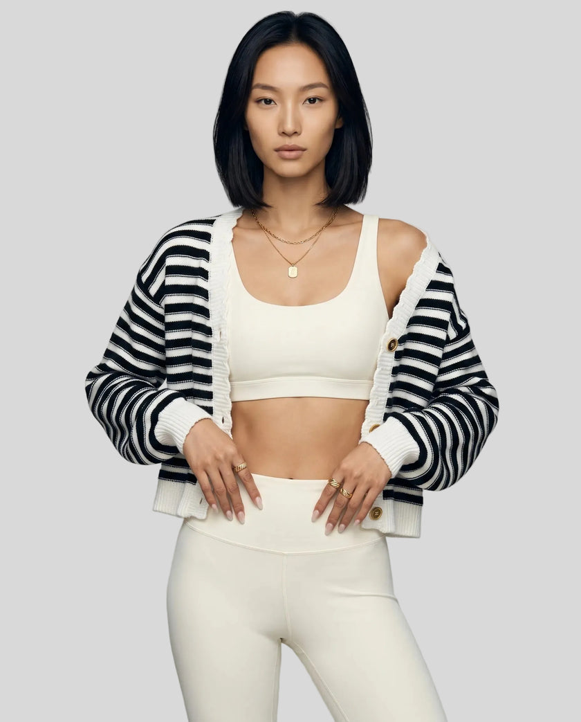 Woman wearing black striped cropped cardigan open over neutral activewear set