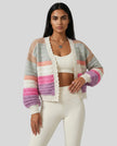 Woman wearing multicolor striped cropped cardigan open over neutral activewear set