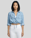Model wearing light blue TieForm Denim Top styled with neutral bottoms showing adjustable tie waist fit