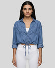 Model wearing medium blue TieForm Denim Top styled with neutral bottoms showing adjustable tie waist fit