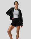 Model wearing Athlesi black TrackEase jacket and shorts set full body front