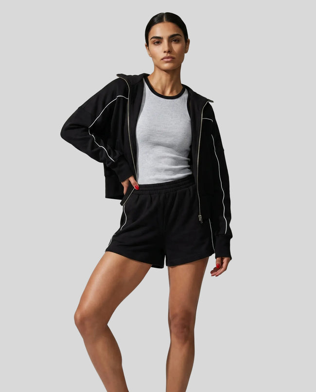 Model wearing Athlesi black TrackEase jacket and shorts set full body front