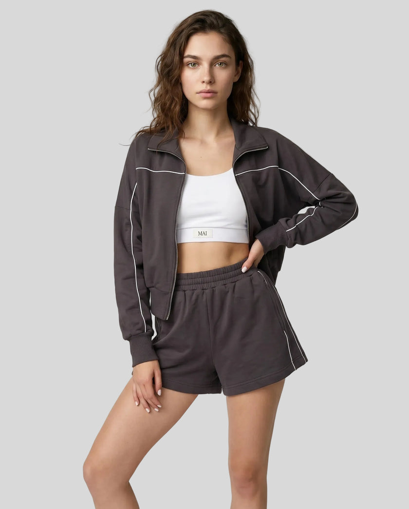 Mid body view of model wearing Athlesi brown TrackEase jacket and shorts set