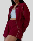 Close-up of Athlesi burgundy TrackEase jacket with contrast piping detail